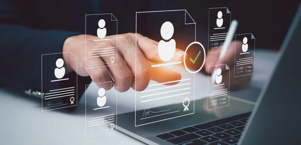 Business professional using recruitment management software on a laptop to review and select candidate profiles digitally.