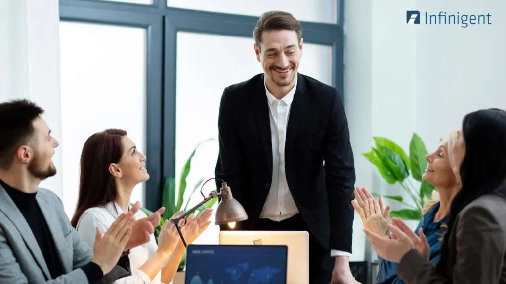 Team applauding a manager during a meeting, representing employee engagement, continuous feedback, and positive workplace culture.