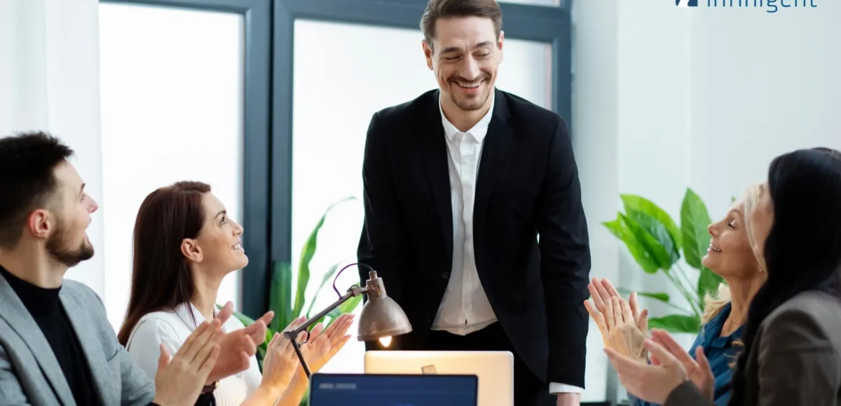Team applauding a manager during a meeting, representing employee engagement, continuous feedback, and positive workplace culture.